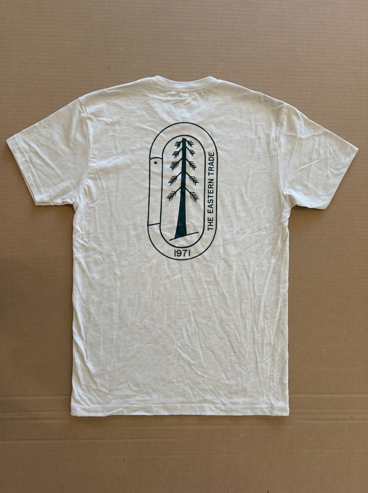 White t-shirt with a black logo on a brown background